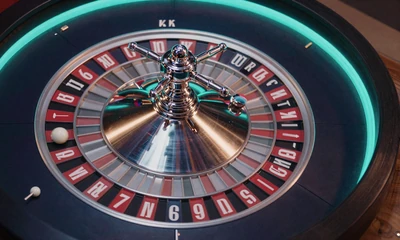 Rotierendes Roulette-Rad mit silberner Kugel unter blauem Neonlicht